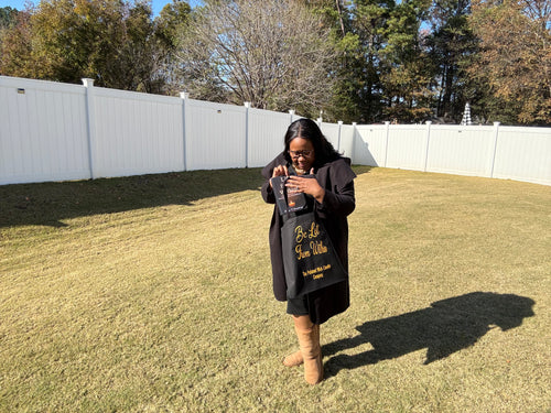 Woman holding a product in a backyard with trees and a white fence in the background