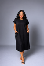 Woman wearing a black dress against a gray background
