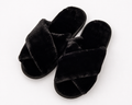 Pair of black fluffy slippers on a white background