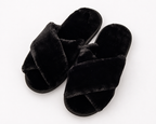 Pair of black fluffy slippers on a white background