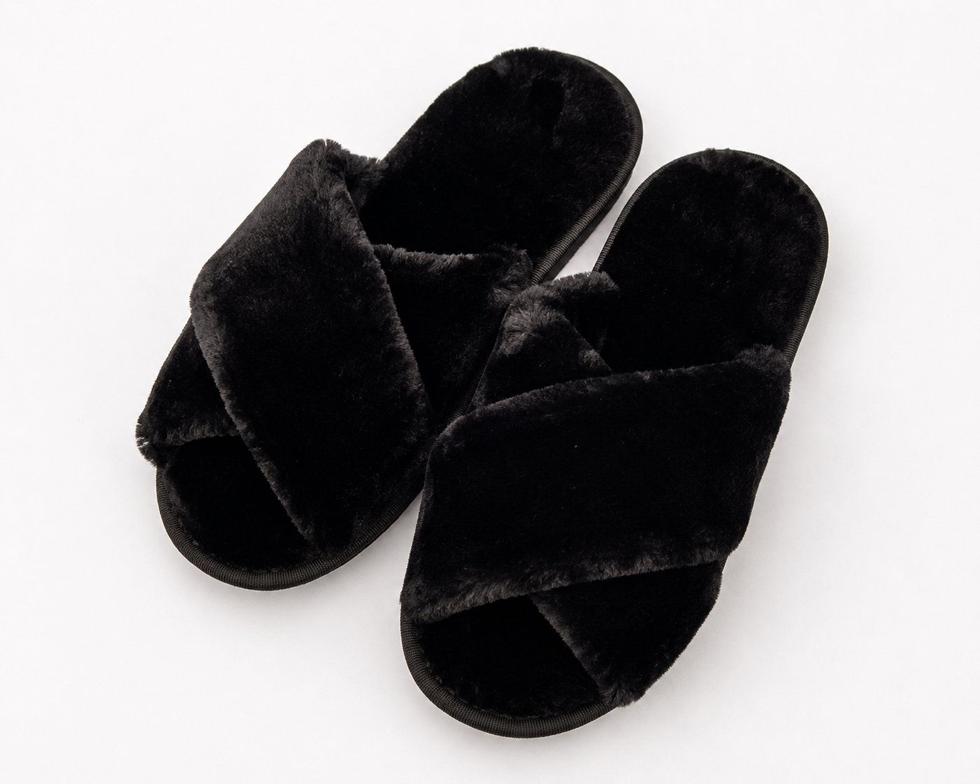 Pair of black fluffy slippers on a white background
