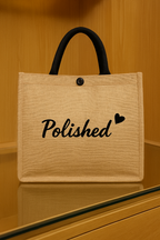 Beige tote bag with 'Polished' text on a wooden surface