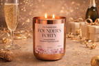 Candle labeled 'Founder's Forty' with champagne and gifts in the background