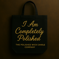Black tote bag with gold text 'I Am Completely Polished' and 'The Polished Wick Candle Company' on a dark background
