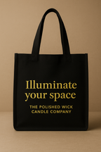 Black tote bag with gold text on a beige background