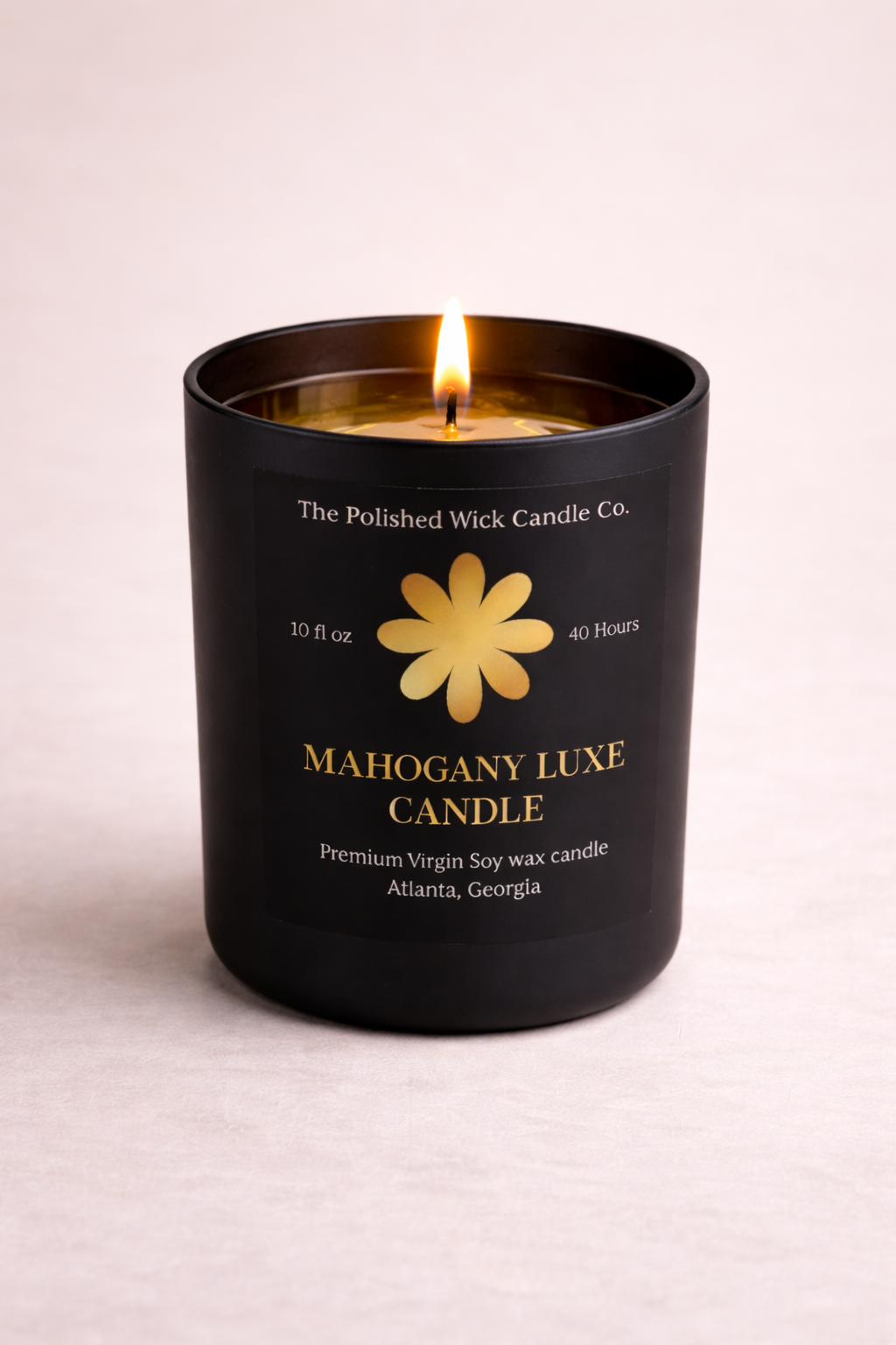 Black candle with a yellow flower logo and text on a light pink background