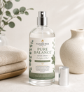Clear room spray bottle labeled 'Pure Balance' on a neutral background with decorative elements.