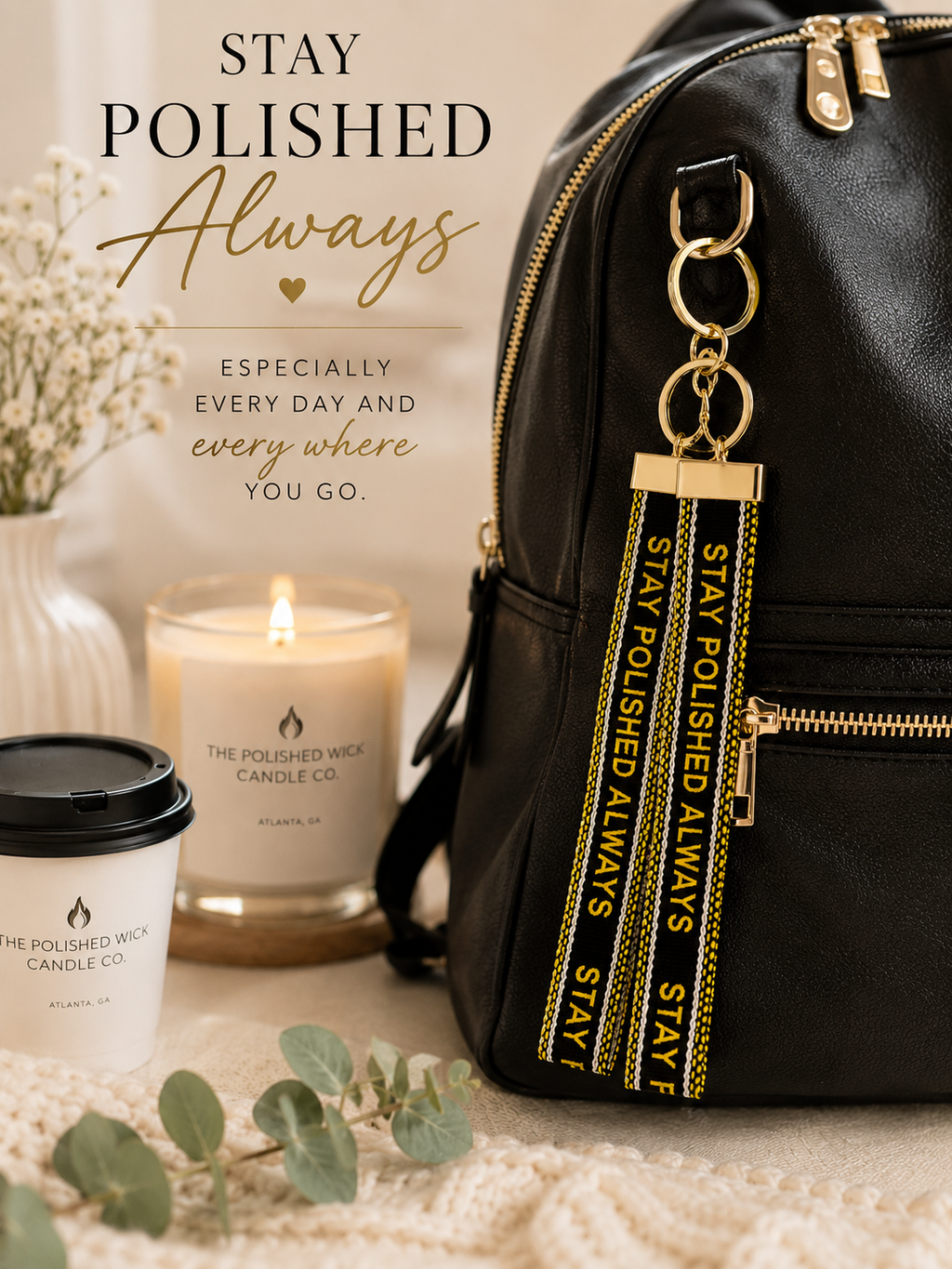 Black backpack with 'Stay Polished Always' keychain, candle, and coffee cup on a neutral background.