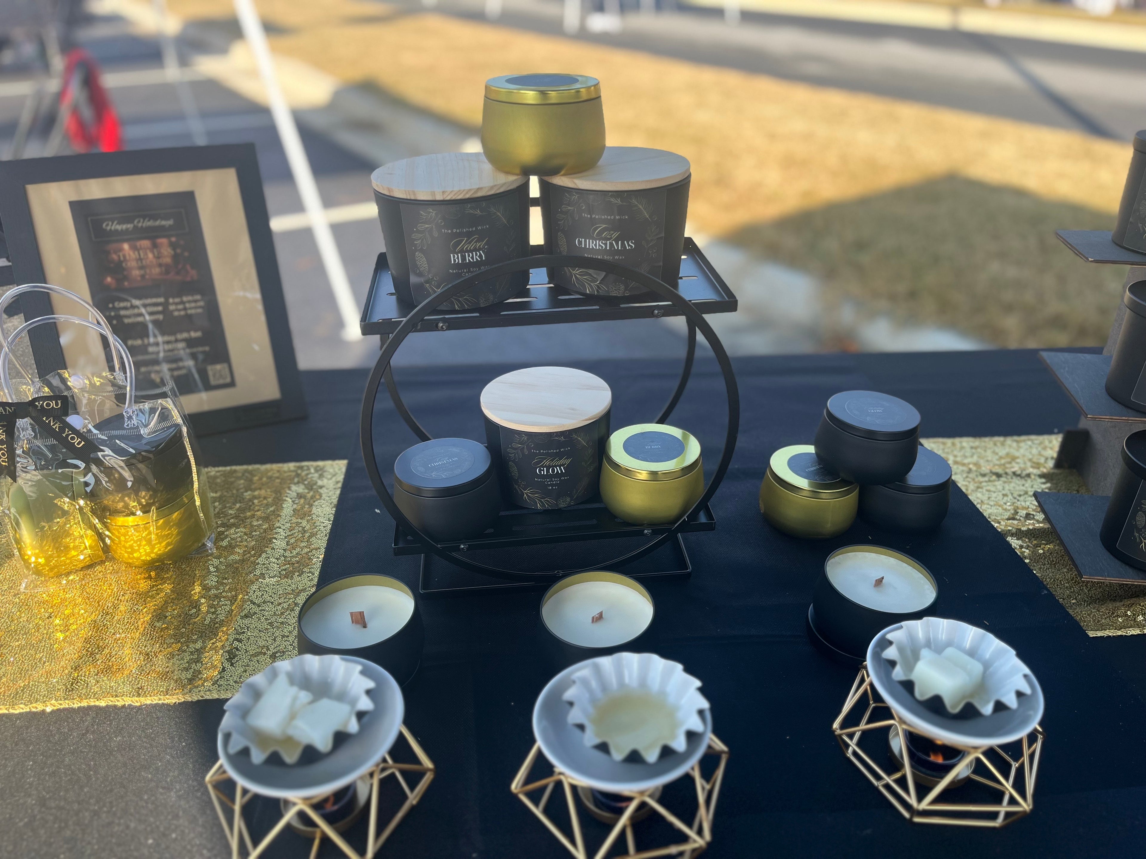 Candle display with various candles on a table outdoors