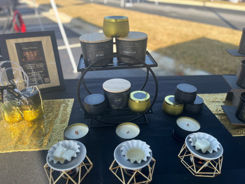 Candle display with various candles on a table outdoors