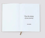 Open book with a motivational quote on a plain background