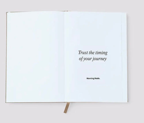 Open book with a motivational quote on a plain background