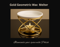 Gold geometric wax melter with a lit candle on a reflective surface