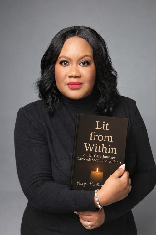 Woman holding a book titled 'Lit from Within' against a gray background