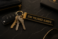 Keychain with keys and 'Stay Polished Always' tag on a dark surface