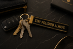 Keychain with keys and 'Stay Polished Always' tag on a dark surface